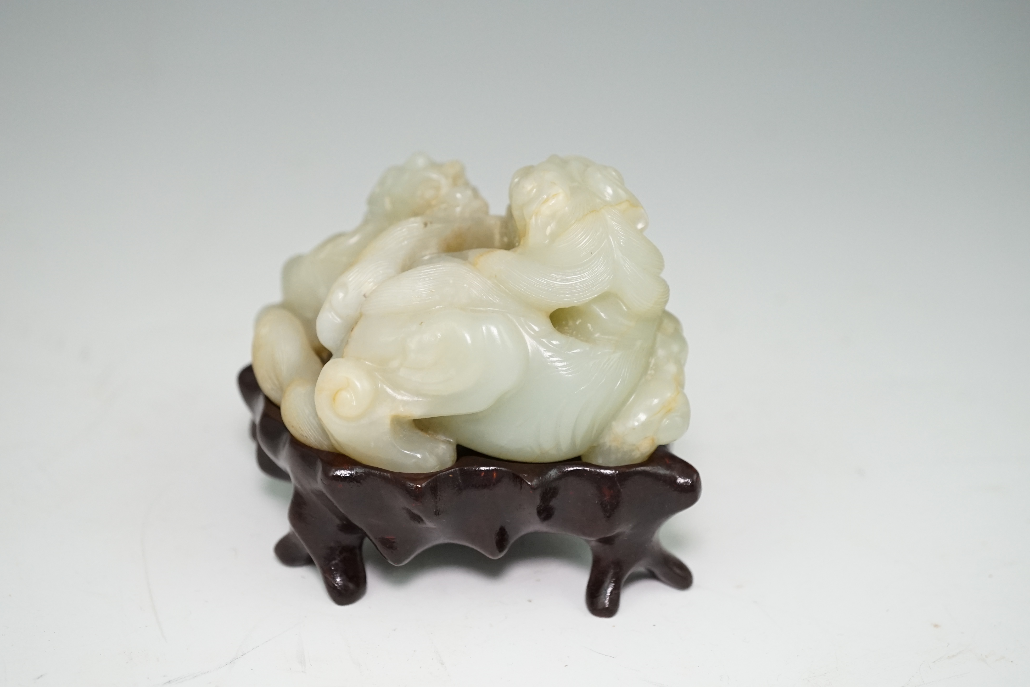 A Chinese celadon and russet jade group of two lion-dogs, 19th century